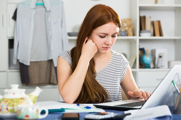 La mujer joven está teniendo problemas con el proyecto para el trabajo