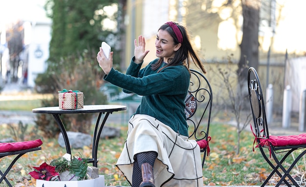 Mujer joven con estilo con cajas de regalo, concepto de compras navideñas, compra de regalos para familiares y amigos.