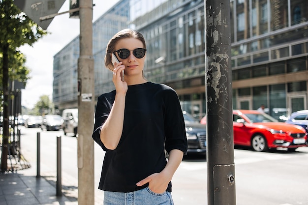 Mujer joven con estilo hablando por teléfono en la ciudad