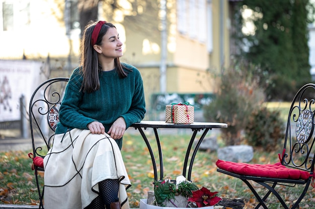 Mujer joven con estilo en un paseo después de hacer compras preparaciones navideñas