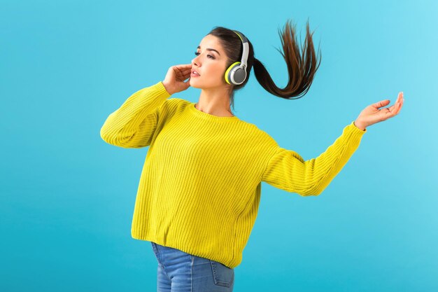 Mujer joven con estilo sosteniendo escuchando música en auriculares