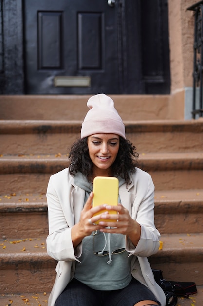 Mujer joven con estilo tomando selfie mientras explora la ciudad