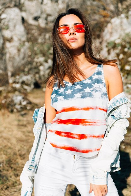 Mujer joven con estilo en top y gafas de sol