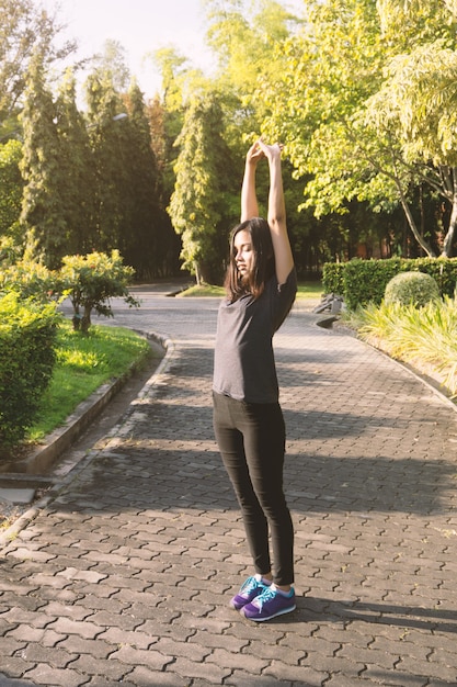 Foto gratuita mujer joven estirando sus brazos al aire libre