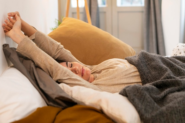 Mujer joven, estirar, en cama