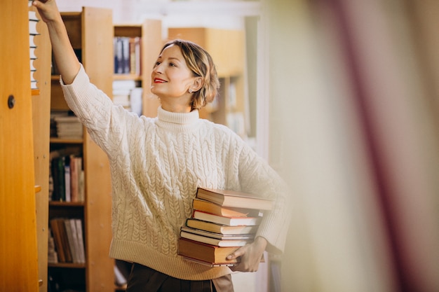 Foto gratuita mujer joven estudiando en la biblioteca