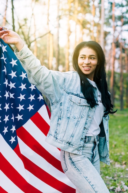 Foto gratuita mujer joven étnica ondeando la bandera de estados unidos