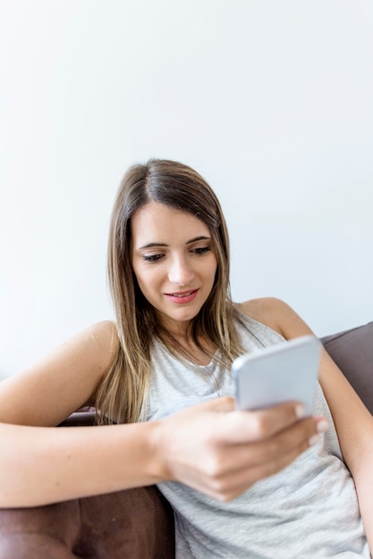 Mujer joven excribiendo mensaje en el móvil