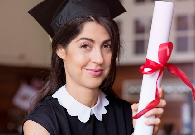 Mujer joven exitosa posando con su diploma