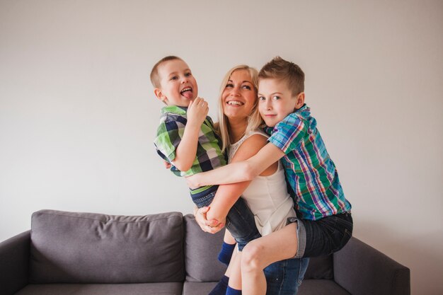 Mujer joven feliz abrazando a sus hijos