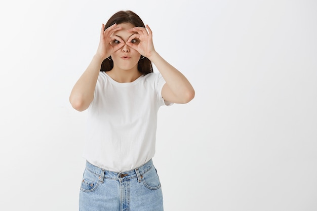 Mujer joven feliz y alegre posando contra la pared blanca