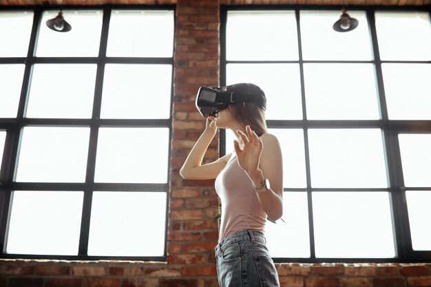 Mujer joven feliz con auriculares Vr. Jugando en casa