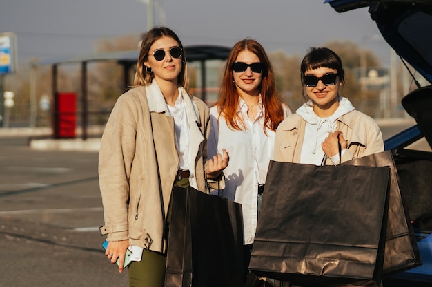 Mujer joven feliz con bolsas de compras caminando en la calle.