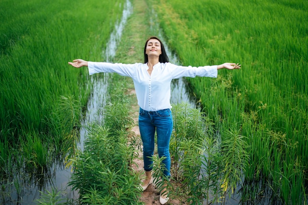 Mujer joven feliz en un campo verde en un día soleado