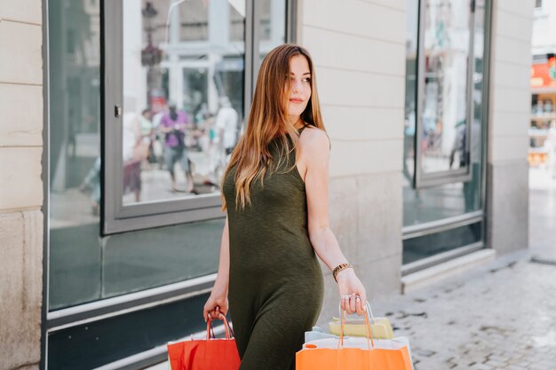 Mujer joven feliz de compras en la ciudad