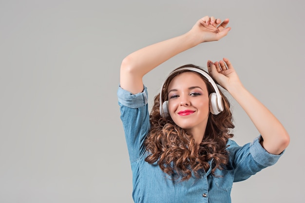 Mujer joven feliz escuchando música con auriculares