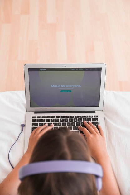 Mujer joven feliz escuchando música en la cama