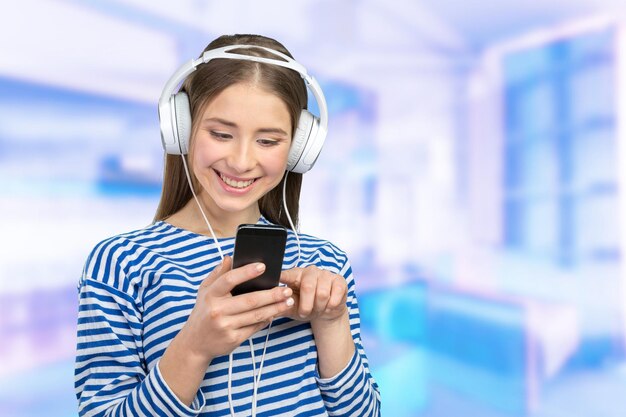 Mujer joven feliz escuchando música