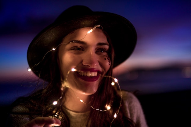 Mujer joven feliz con la guirnalda ardiente en la cabeza