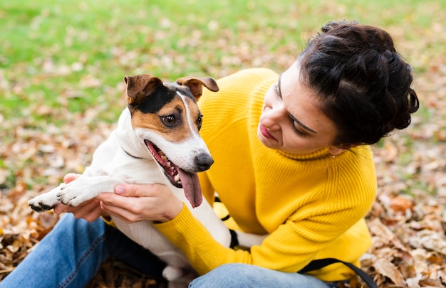 Mujer joven feliz jugando con su perro