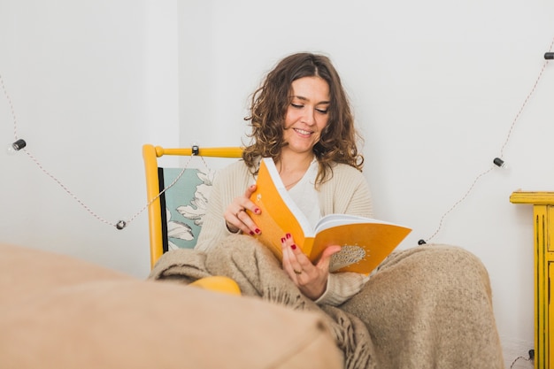 Foto gratuita mujer joven feliz leyendo un libro