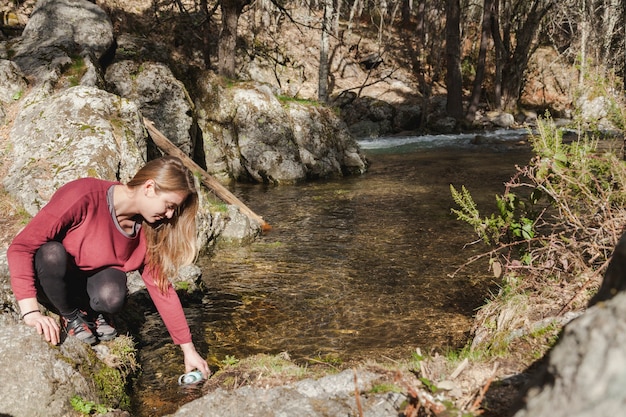 Mujer joven feliz llenando su botella de agua