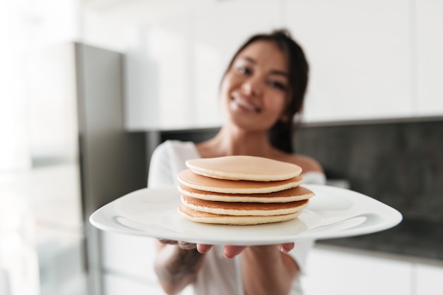 Mujer joven feliz con panqueques.