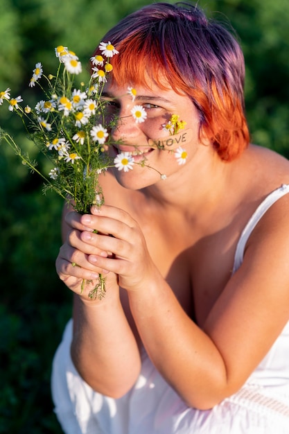 Mujer joven feliz posando con flores