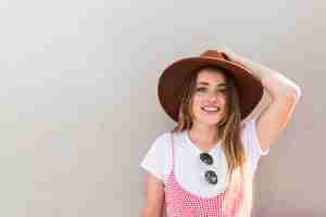 Foto gratuita mujer joven feliz posando con sombrero