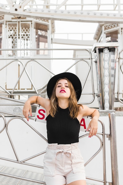 Foto gratuita mujer joven feliz posando con sombrero