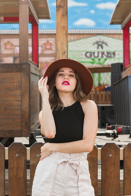 Mujer joven feliz posando con sombrero