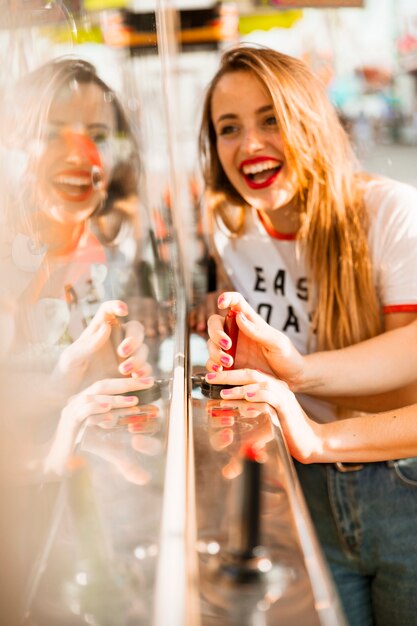 Mujer joven feliz que se divierte en el parque de atracciones