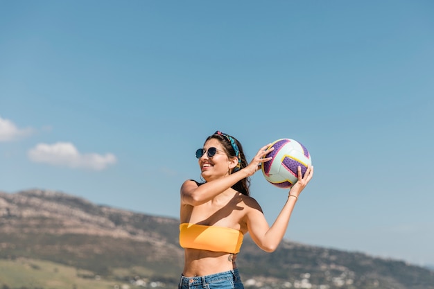 Mujer joven feliz que juega con la bola
