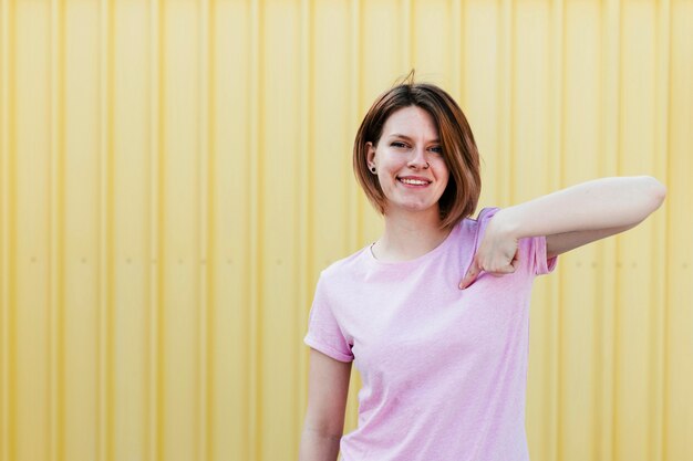 Mujer joven feliz que señala el dedo hacia sí misma