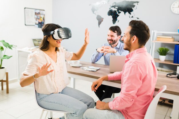 Mujer joven feliz que usa un casco de realidad virtual en la agencia de viajes para mirar fotos y experimentar un nuevo país para su próximo destino