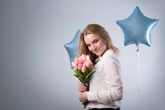 Mujer joven feliz con el ramo de tulipanes