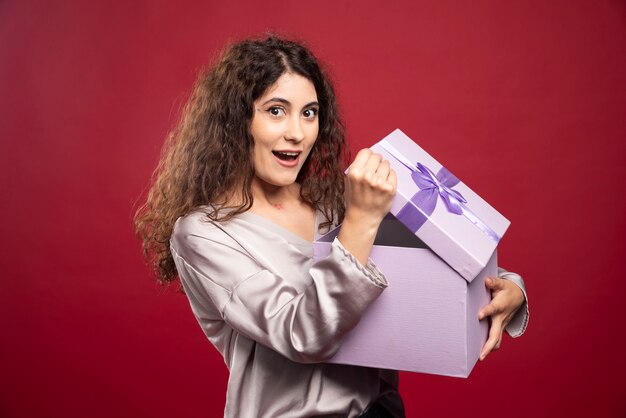 Mujer joven feliz sorprendida por su regalo.