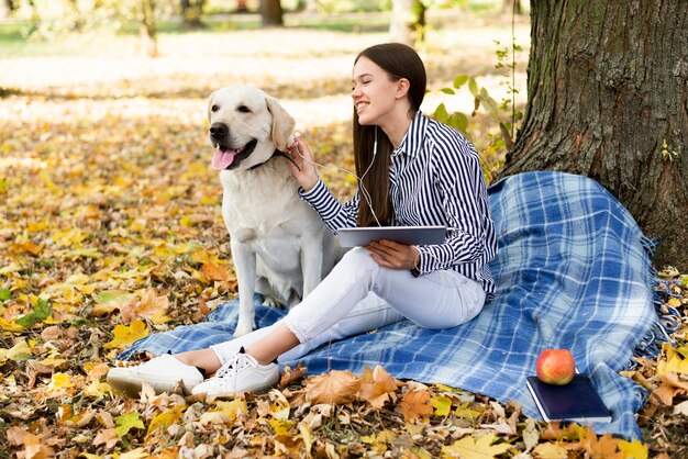 Mujer joven feliz con su perro en el parque