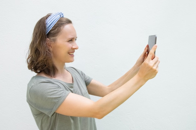 Mujer joven feliz con tableta tomando fotos