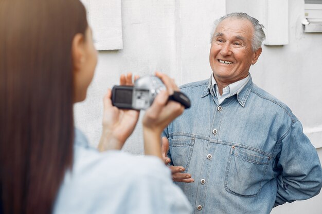 Foto gratuita mujer joven filmando a su abuelo