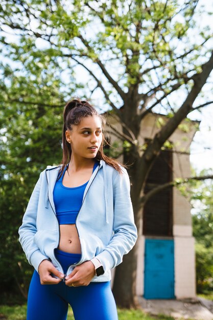 Mujer joven fitness camina en el parque y posando