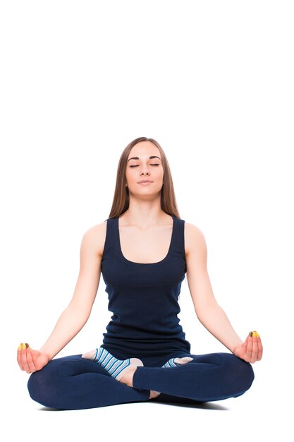 Mujer joven fitness haciendo yoga sobre fondo blanco.