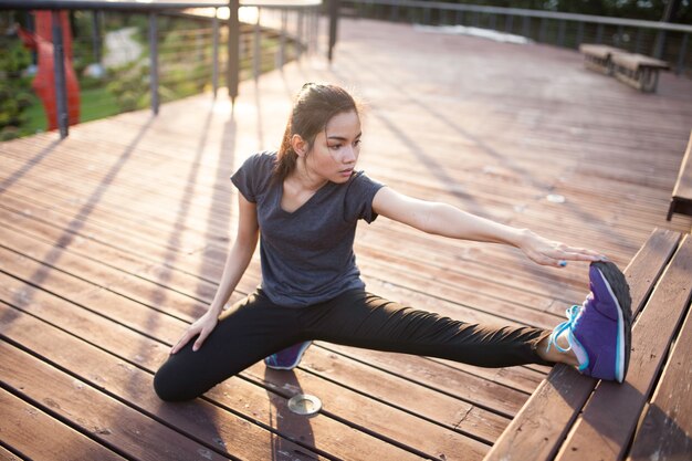 Mujer joven flexible estirando su pierna izquierda