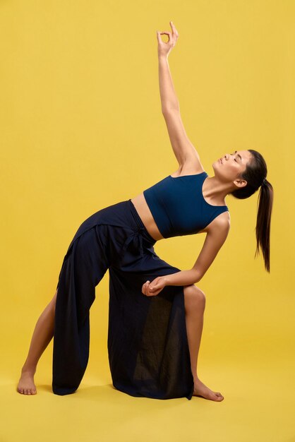 Mujer joven flexible practicando la postura de yoga