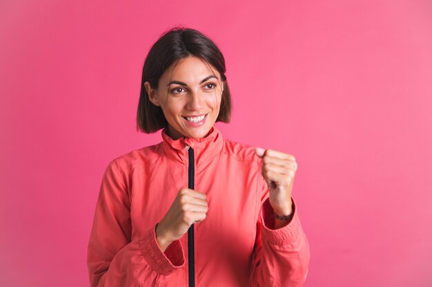 Mujer joven en forma en chaqueta de deporte en rosa lucha contra el gesto de la caja