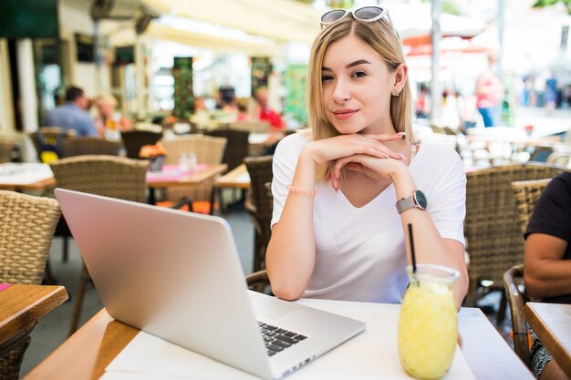 Mujer joven con gafas en la cabeza sonriendo con alegría