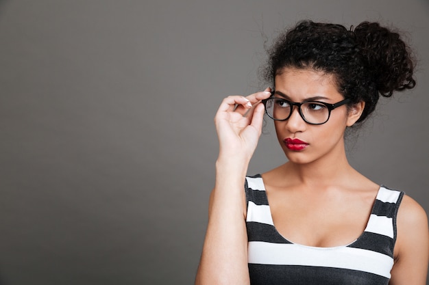 Mujer joven con gafas y camisa a rayas