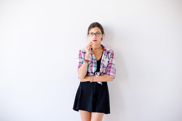 Mujer joven con gafas de moda y camisa a cuadros de colores