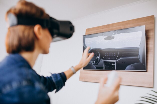 Mujer joven con gafas de realidad virtual y jugando juegos virtuales con control remoto