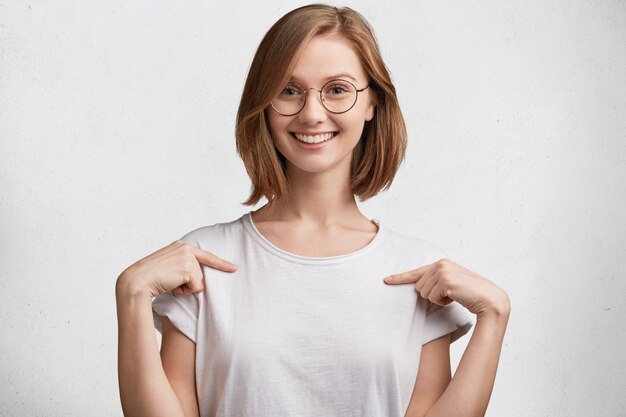 Mujer joven con gafas redondas y camiseta blanca